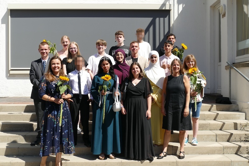 Das Bild zeigt: Die 10. Klasse und ihre zwei Klassenlehrerinnen. Sie halten Sonnenblumen in den Händen.