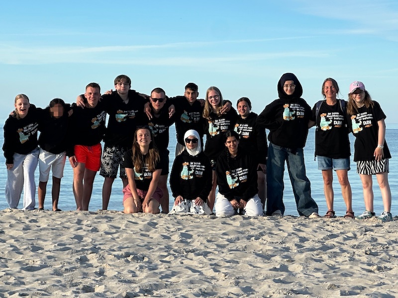Das Bild zeigt: Die 10. Klasse in ihrem Abschluss-Hoodies am Strand. Im Hintergrund ist die Ostsee.